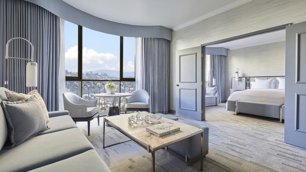 Bright hotel suite with a separate seating area and city views