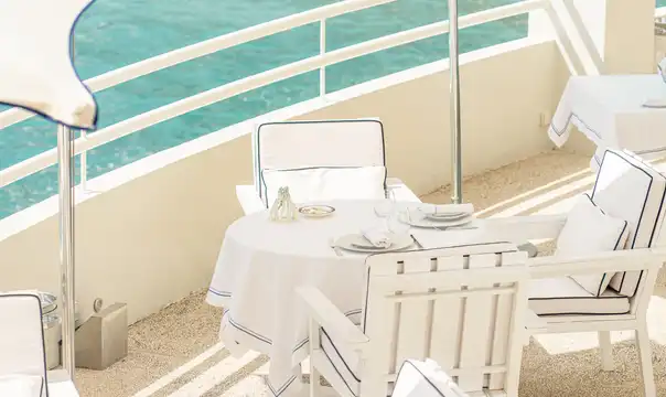 Seafront terrace table overlooking turquoise water in Monaco