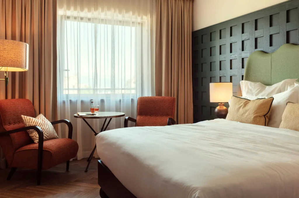 Guest room with green headboard at The Hoxton, Rome