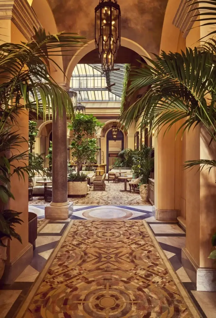 Ornate hotel corridor with palm trees and patterned flooring